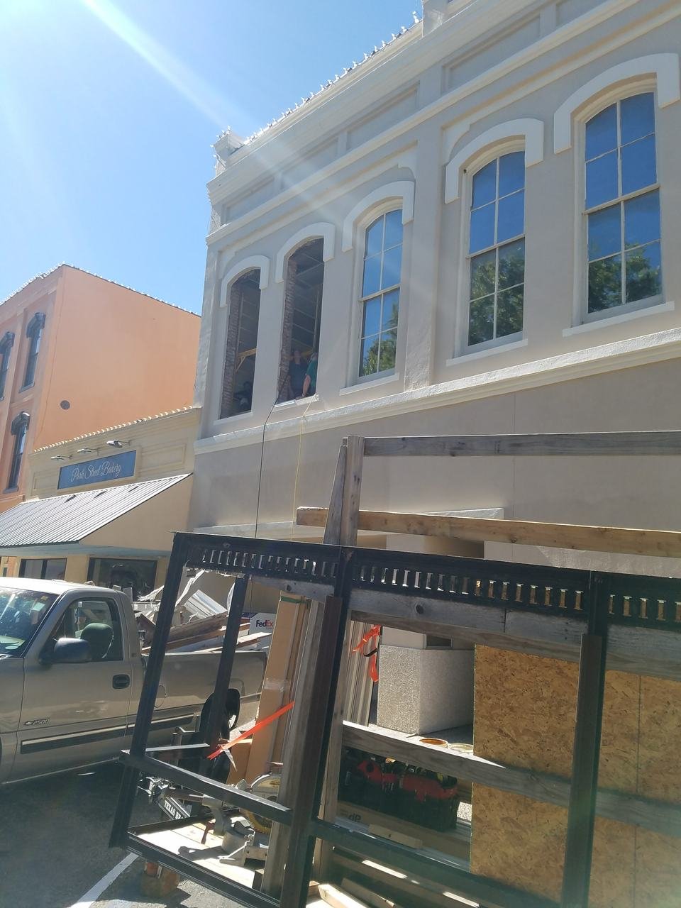 Crew working in the window openings of a downtown Brenham, TX storefront during restoration